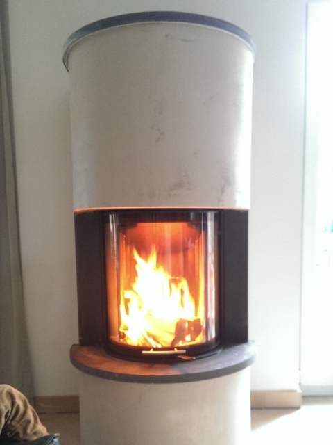 Runder weißer Heizkamin mit brennendem Feuer