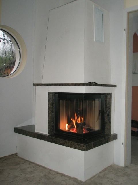Weißer Eckkamin mit brennendem Feuer
