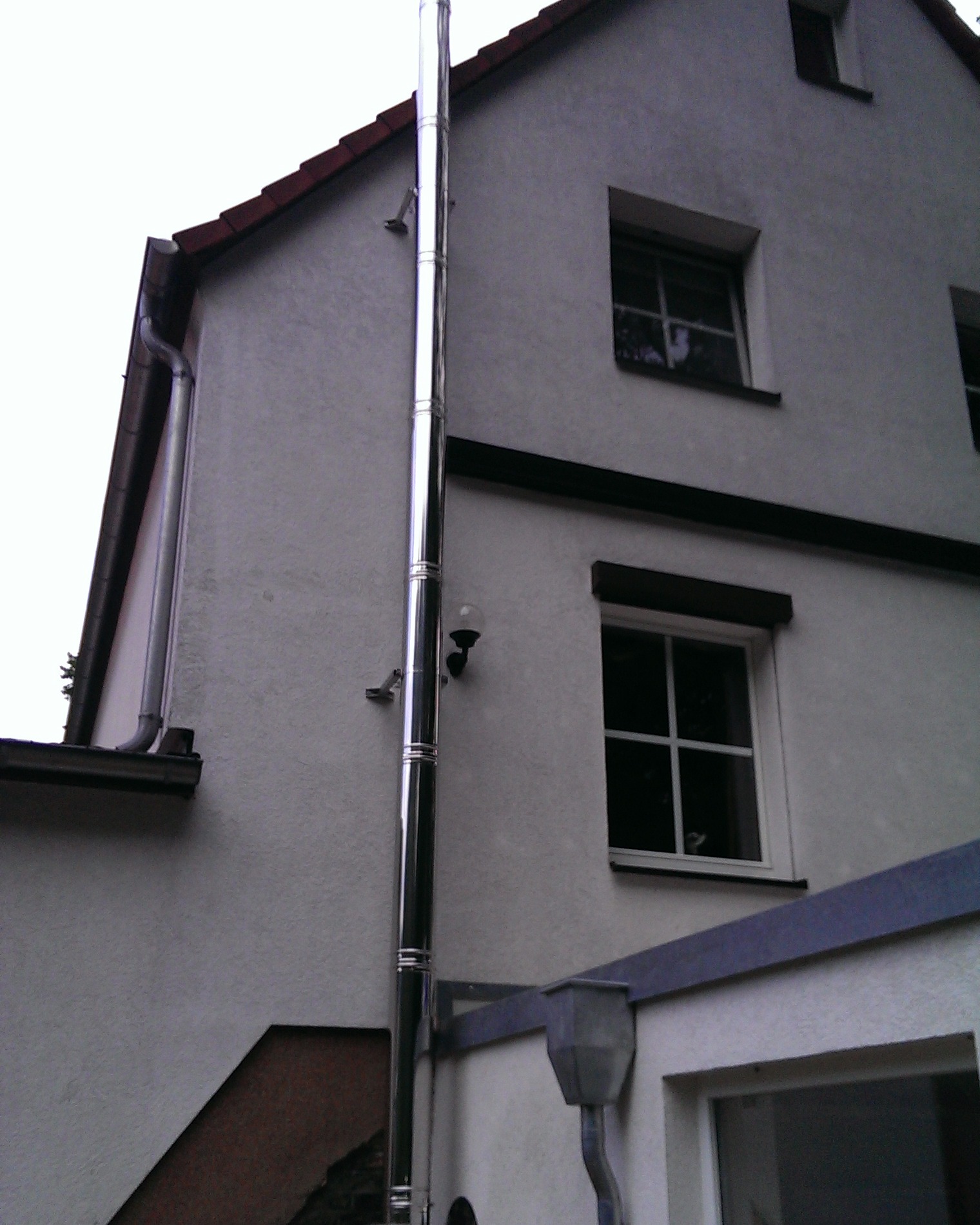 Edelstahlschornstein an der Fassade eines Wohnhauses