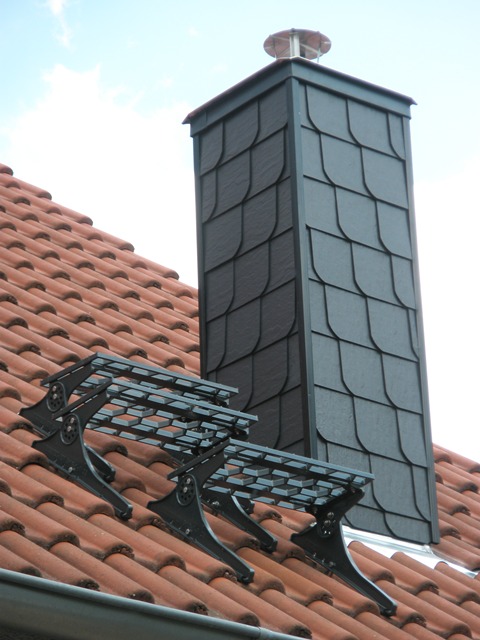 Schornsteinkopf mit Schieferverkleidung auf einem Ziegeldach